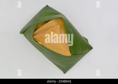 Crema pasticcera al cocco condita con riso glutinoso e appiccicoso avvolto in foglie di banana, khao niao sangkhaya, una variante tailandese del popolare dessert del sud-est asiatico Foto Stock