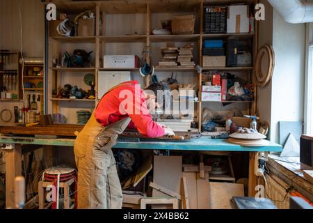 I falegnami maschi mirati utilizzano lavori a scalpello con mobili in legno fatti a mano in falegnameria. Foto Stock
