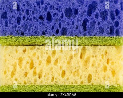 Primo piano di spugne impilate orizzontalmente in diversi colori. Le spugne sono disposte nel seguente ordine: Blu, verde e giallo verde Foto Stock