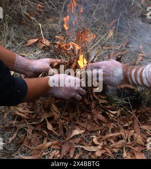 Cerimonia aborigena australiana, mans mani con erba asciutta a terra, un rito rituale in un evento della comunità ad Adelaide, Australia meridionale Foto Stock