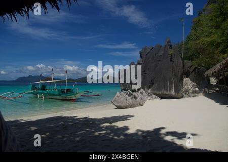 un luogo popolare dove i turisti si fermano per pranzare e rilassarsi con le limpide acque blu e le morbide. Spiaggia di sabbia bianca sull'isola di Banul vicino a Coron Foto Stock