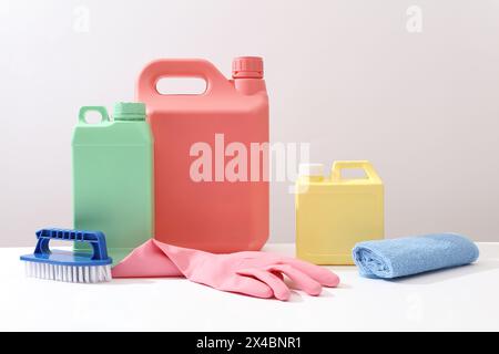 Scena pubblicitaria per lavori domestici e forniture professionali di servizi di pulizia. Mockup di contenitori in plastica per detersivo decorato con guanto in gomma Foto Stock