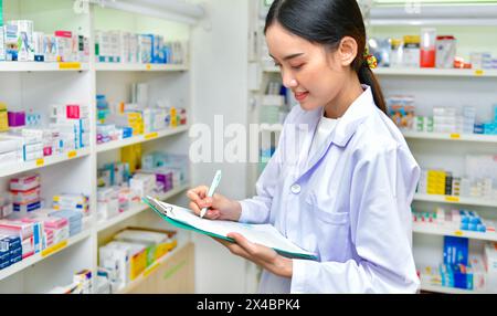 Farmacista che riempie la prescrizione nel negozio di farmacia Foto Stock