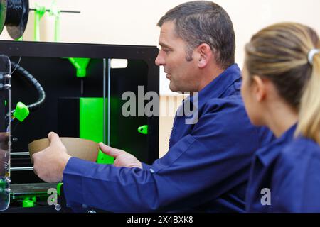 operai di stampanti 3d in fabbrica Foto Stock