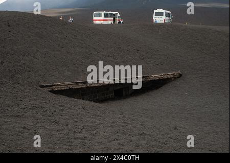 Etna in Sicilia, Italia: A 2.900 metri sul livello del mare, sulle pendici del cratere centrale del vulcano, fuoristrada e veggenti con in primo piano il Rifugio Torre del Filosofo, sepolto in torrenti di lava fredda (sciare). Foto Stock