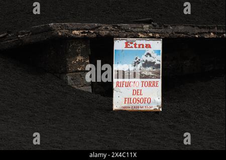 Un vulcanologo primitivo. Nota sul Rifugio Torre del filosofo, sepolto in torrenti di lava fredda (sciare), a 2.900 metri sul livello del mare sull'Etna in Sicilia, Italia. Chiamato così in onore di Empedocle (492 a.c. ca. - 430 a.C. circa), filosofo greco di Agrigento che, secondo la leggenda, scalò l'Etna per studiare le sue eruzioni e si gettò nella bocca del vulcano per scoprirne i segreti. Foto Stock