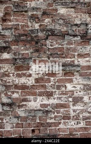 Un vecchio muro di mattoni. Antico sfondo in mattoni rossi con interstrato bianco tra i mattoni. Foto verticale. Foto di alta qualità. Può essere utilizzato per la progettazione di banner e materiali promozionali. Foto Stock