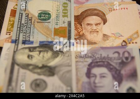 In questa foto, puoi vedere una nota di rial iraniano del 5000, una banconota da 100 dollari e una banconota da 20 GB. La rivolta iraniana sta cadendo a causa delle sanzioni. Foto Stock