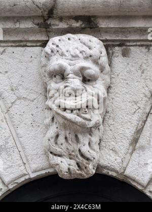 Italia, Venezia. Grottesco intaglio in pietra di una figura gargoyle maschile sull'esterno della chiesa di Santa Maria Formosa. Foto Stock