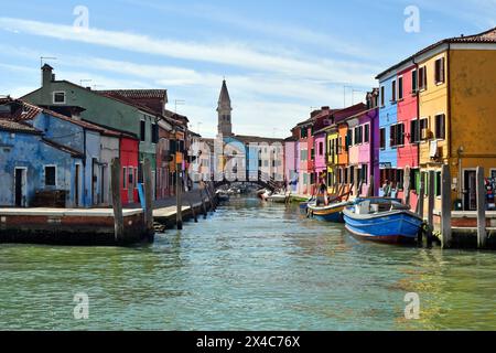 Burano, Italia - 17 aprile 2024: Vista delle case colorate dell'isola nella laguna di Venezia e della torre pendente della chiesa parrocchiale Foto Stock