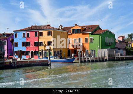 Burano, Italia - 17 aprile 2024: Vista delle case colorate dell'isola nella laguna di Venezia e stazione di servizio con pompe per barche Foto Stock