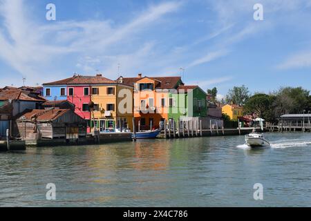 Burano, Italia - 17 aprile 2024: Vista delle case colorate dell'isola nella laguna di Venezia e stazione di servizio con pompe per barche Foto Stock