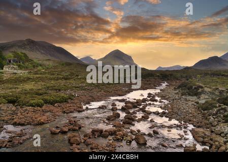 Guardando verso sud-ovest lungo il fiume Sligachan al "Ponte Vecchio". Turisti. Fiume incorniciato contro le montagne Cuillin. Skye. Highlands occidentali, Scozia Foto Stock