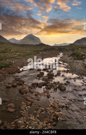 Guardando verso sud-ovest lungo il fiume Sligachan al "Ponte Vecchio". Turisti. Fiume incorniciato contro le montagne Cuillin. Skye. Highlands occidentali, Scozia Foto Stock