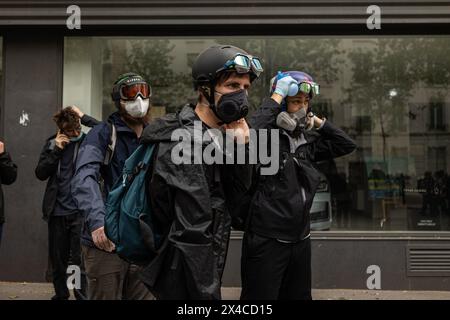 Parigi, Francia. 1° maggio 2024. Un gruppo di dimostranti ha visto indossare occhiali protettivi e maschere antigas per proteggersi dal gas lacrimogeno anti-sommossa durante le dimostrazioni del giorno dei lavoratori. Una giornata piena di scontri tra i gruppi del blocco nero, anarchici e anti-capitalisti, con la polizia divenne il solito nella celebrazione del 1° maggio la giornata dei laburisti a Parigi, lamentandosi del governo del presidente Macron e dei suoi processi di legge politica e sociale. Credito: SOPA Images Limited/Alamy Live News Foto Stock