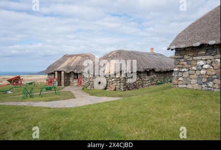 Cottage tradizionali di crofters realizzati in pietra locale e canne per tetti di paglia al museo Skye della vita sull'isola, Isola di Skye, Scozia. Foto Stock