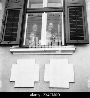 Repubblica Socialista di Romania negli anni '1970 Donne e ragazze in una famiglia viste dietro la finestra di vetro della loro casa, che guardano fuori. Foto Stock