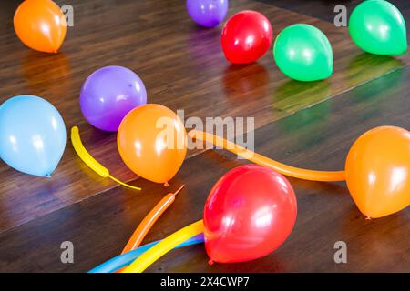 Palloncini multicolore su un pavimento di legno marrone. Festa per bambini o compleanno. Nucleo di bambini. Copia spazio. Foto Stock