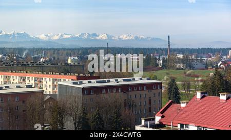Vista panoramica dei tetti di Nowy Targ con montagne Tatra innevate sullo sfondo Foto Stock