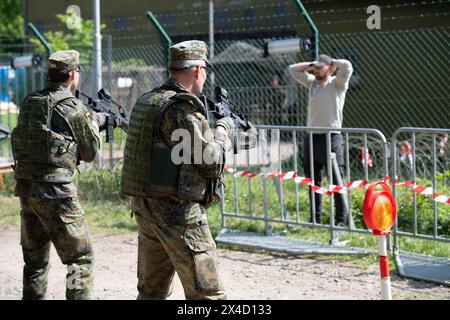 Darstellung: Soldaten bewachen und durchsuchen einen Verdaechtigen, Soldaten ueberpruefen einen LKW in der Fahrzeugschleuse, allgemein, feature, Randmotiv, Symbolfoto Kontrollposten, Checkpoint, Bundeswehr-Uebung AGILES ROSS im Rahmen der bundesweiten Uebung NATIONAL GUARDIAN, Die nordrhein-westfaelischen Heimatschutzkraefte des Heimatschutzregiments 2 aus Muenster uebenin der Wahner Heide bei Troisdorf Altenrath, 02.05.2024, *** illustrazione soldati guardia e ricerca di un sospetto, check point, simbolo di frontiera, checkpoint checkpoint, B. Foto Stock