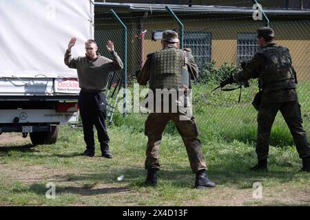 Darstellung: Soldaten bewachen einen Verdaechtigen, Soldaten ueberpruefen einen LKW in der Fahrzeugschleuse, allgemein, feature, Randmotiv, Symbolfoto Kontrollposten, Checkpoint, Bundeswehr-Uebung AGILES ROSS im Rahmen der bundesweiten Uebung NATIONAL GUARDIAN, Die nordrhein-westfaelischen Heimatschutzkraefte des Heimatschutzregiments 2 aus Muenster uebenin der Wahner Heide bei Troisdorf Altenrath, 02.05.2024, *** soldati illustrazioni a guardia di un sospetto, soldati che controllano un camion, blocco di frontiera, simbolo, veicolo, posto di controllo, esercizio Bundeswehr AGI Foto Stock