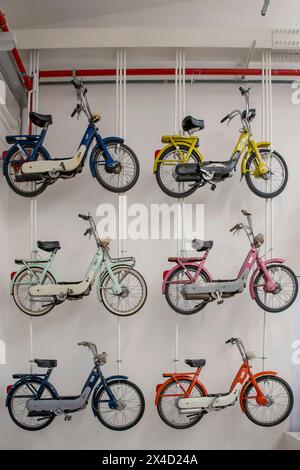 Vecchi modelli di scooter Piaggio Ciao appesi alla parete del museo, Pontedera, Italia Foto Stock