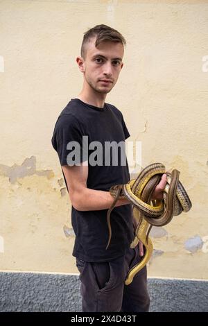 Francesco è un giovane "serparo" di Cocullo. I "serpari" sono incaricati di catturare i serpenti e di posizionarli sulla statua di San Domenico durante la cerimonia religiosa/pagana. La più famosa e misteriosa celebrazione folcloristica abruzzese è un evento in cui i costumi pagani e la tradizione cristiana si fondono: La devozione a San Domenico, protettore contro il morso dei rettili, si intreccia con il rituale arcaico dei "serpari". Questa usanza è legata ai riti pagani dei Marsi, un antico popolo italico. In epoca contemporanea, è celebrato in onore di San Domenico, che si crede sia il pr Foto Stock