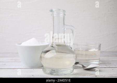 Aceto e bicarbonato su tavolo di legno bianco Foto Stock