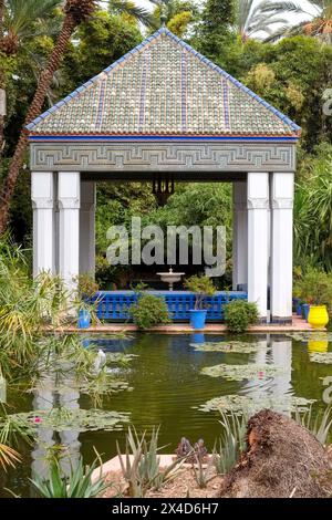 Marrakech, Marocco. Tetto in piastrelle marocchine in cima al gazebo e al tranquillo laghetto. Foto Stock