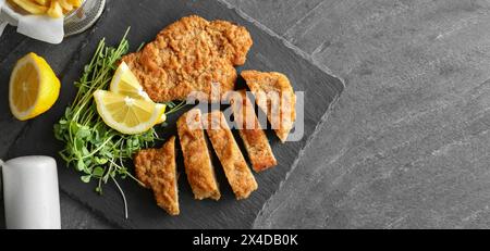 Gustosi schnitzel serviti su un tavolo grigio, vista dall'alto. Design banner Foto Stock