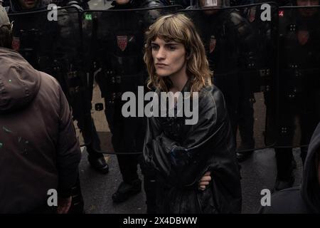 Parigi, Francia. 1° maggio 2024. Un manifestante di fronte a un muro della polizia antisommossa del CRS che blocca il gran numero di manifestanti si è riunito vicino a Place de la Nation, il punto finale della marcia. Le proteste annuali del giorno di maggio hanno visto più di 120.000 marzo in tutta la Francia con un grande raduno a Parigi che ha portato a scontri tra manifestanti e polizia antisommossa, con 45 arresti effettuati nella capitale. (Foto di Graham Martin/SOPA Images/Sipa USA) credito: SIPA USA/Alamy Live News Foto Stock