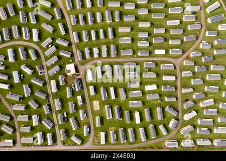 Vista aerea dall'alto verso il basso di un grande gruppo di roulotte statiche in un parcheggio per roulotte o in una casa vacanze Foto Stock
