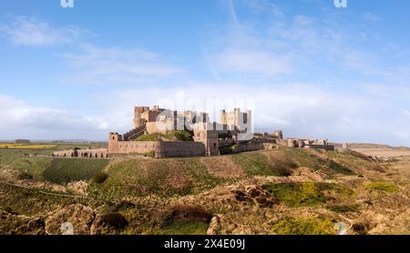 CASTELLO DI BAMBURGH, NORTHUMBERLAND, REGNO UNITO - 23 APRILE 2024. Vista panoramica aerea del castello di Bamburgh e delle dune di sabbia sullo splendido Northumberlan Foto Stock