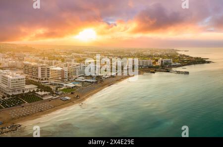 Fig Tree Bay a Protaras, Cipro, cattura un tramonto mozzafiato sul Mediterraneo. Questa immagine mostra l'idilliaca miscela di hotel di lusso, bea sabbiosa Foto Stock