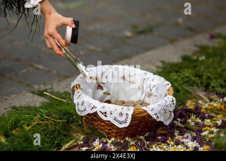 Colmenar Viejo, Madrid, Spagna. 2 maggio 2024. Una ragazza mette le monete in un cestino per offrire a la MAYA, durante la celebrazione di ''la Maya'', nella città di Colmenar Viejo a Madrid. Las Mayas sono ragazze tra i 7 e i 14 anni che siedono per due ore in un altare decorato con fiori e piante per celebrare l'inizio della primavera. Questa tradizione originaria della città di Colmenar Viejo, Madrid, risale al medioevo, secondo antichi documenti. (Immagine di credito: © Luis Soto/ZUMA Press Wire) SOLO PER USO EDITORIALE! Non per USO commerciale! Foto Stock