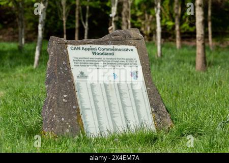 Una targa di pietra in un Memorial Wood a St Ives Estate, Bingley. I nomi di coloro che hanno fatto piantare un albero in loro memoria sono elencati sulla targa. Foto Stock