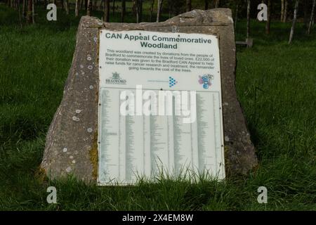 Una targa di pietra in un Memorial Wood a St Ives Estate, Bingley. I nomi di coloro che hanno fatto piantare un albero in loro memoria sono elencati sulla targa. Foto Stock