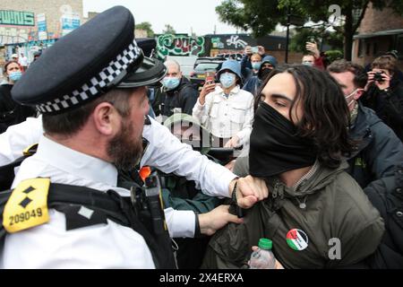 Londra, Regno Unito. 2 maggio 2024. Agenti di polizia e un manifestante si scontrano durante la dimostrazione. Manifestanti e polizia si sono scontrati durante una protesta nel sud di Londra per il previsto trasferimento di richiedenti asilo alla chiatta Bibby Stockholm nel Dorset. Credito: SOPA Images Limited/Alamy Live News Foto Stock