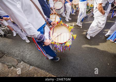 Batterista e batteria dei Blue Ribbon con ghirlande di campanelli e sciabole al festival "Obby 'Oss", un evento popolare annuale del May Day a Padstow, Cornovaglia Foto Stock