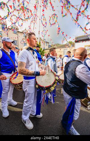 Batterista e batteria dei Blue Ribbon con ghirlande di campanelli e sciabole al festival "Obby 'Oss", un evento popolare annuale del May Day a Padstow, Cornovaglia Foto Stock