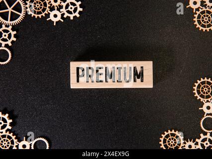 Concetto aziendale. Una calcolatrice si trova su una superficie marrone, una mano con una penna fa un'iscrizione su un adesivo - ASSICURAZIONE PREMIUM Foto Stock