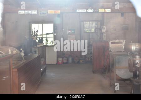 Spencer, Missouri, Stati Uniti-4.13.24. Guardando attraverso la vetrina del vecchio negozio Feed and Seed, si può ammirare una vista nebulosa di alcuni prodotti del passato. Foto Stock