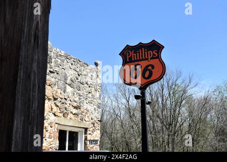 Spencer, Missouri, Stati Uniti, 13-4-24 una vecchia stazione Phillips 66 vanta un'antica insegna nera e arancione Phillips 66. La città vecchia è stata restaurata. Foto Stock