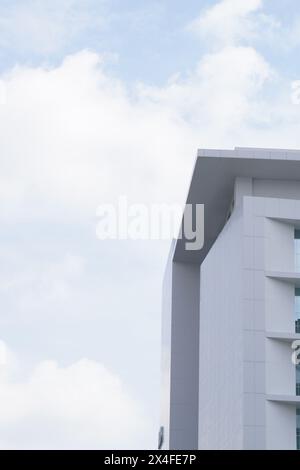 Un edificio minimalista a più piani con un motivo a scacchi e vetro su ogni livello e un cielo limpido Foto Stock