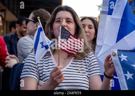 New York, Stati Uniti. 2 maggio 2024. Una donna ha due piccole bandiere, una americana e una israeliana. Le tensioni aumentano mentre i manifestanti pro-palestinesi alla New School di New York si incontrano con i contro-manifestanti pro-Israele. L'organizzazione New School Students for Justice in Palestine ha istituito un accampamento all'interno dell'edificio della scuola 11 giorni fa, chiedendo alla scuola di rivelare e cedere qualsiasi legame finanziario con Israele. (Foto di Syndi Pilar/SOPA Images/Sipa USA) credito: SIPA USA/Alamy Live News Foto Stock