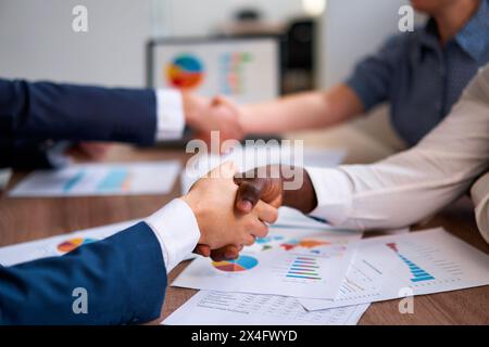 Il team di business multirazziale conclude i colloqui con una stretta di mano sui rapporti finanziari, una negoziazione di successo, una partnership aziendale. Professionisti diversi Foto Stock