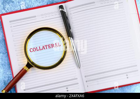 Affari e finanza. L'iscrizione - MATERIALE COLLATERALE scritto tramite una lente di ingrandimento in un notebook aziendale. Foto Stock