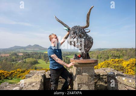 Scottish Borders, Regno Unito. 2 maggio 2024. 2 maggio 2024 Meteo, Arti Brandon Beck è un fabbro di successo con sede negli Scottish Borders, ma anche uno scultore di talento. Nella foto, con la sua ultima creazione di un drammatico busto di una mucca delle Highland realizzato con ferro di cavallo forgiato e rimodellato. Le sue opere saranno esposte alla mostra d'arte Art in Antrim, che si tiene questo fine settimana festivo ad Ancrum, negli Scottish Borders. Nella foto, si indossano i ritocchi finali prima che i lavori si svolgano alla mostra di questo fine settimana ad Ancrum. Crediti immagine: phil wilkinson/Alamy Live News Foto Stock