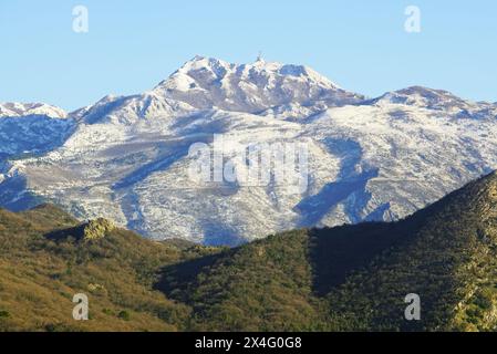 Vista del Monte Lovcen innevato contro un cielo blu e un frammento del Monte Vrmac sottostante, un paesaggio montano invernale dal Montenegro. Foto Stock