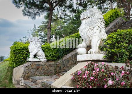 Statue di leoni. Due leoni di marmo siedono su una scala su piedistalli di fronte al parco pubblico di da Lat Vietnam. Foto di viaggio, nessuno Foto Stock